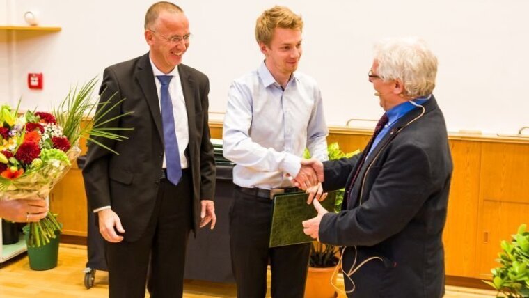 Dr. Rudolf von Bünau (links) und der Dekan Prof. Wipf  (rechts) verleihen den ZEISS Ph.D. Award 2019 an M.Sc. Wilhelm Eschen